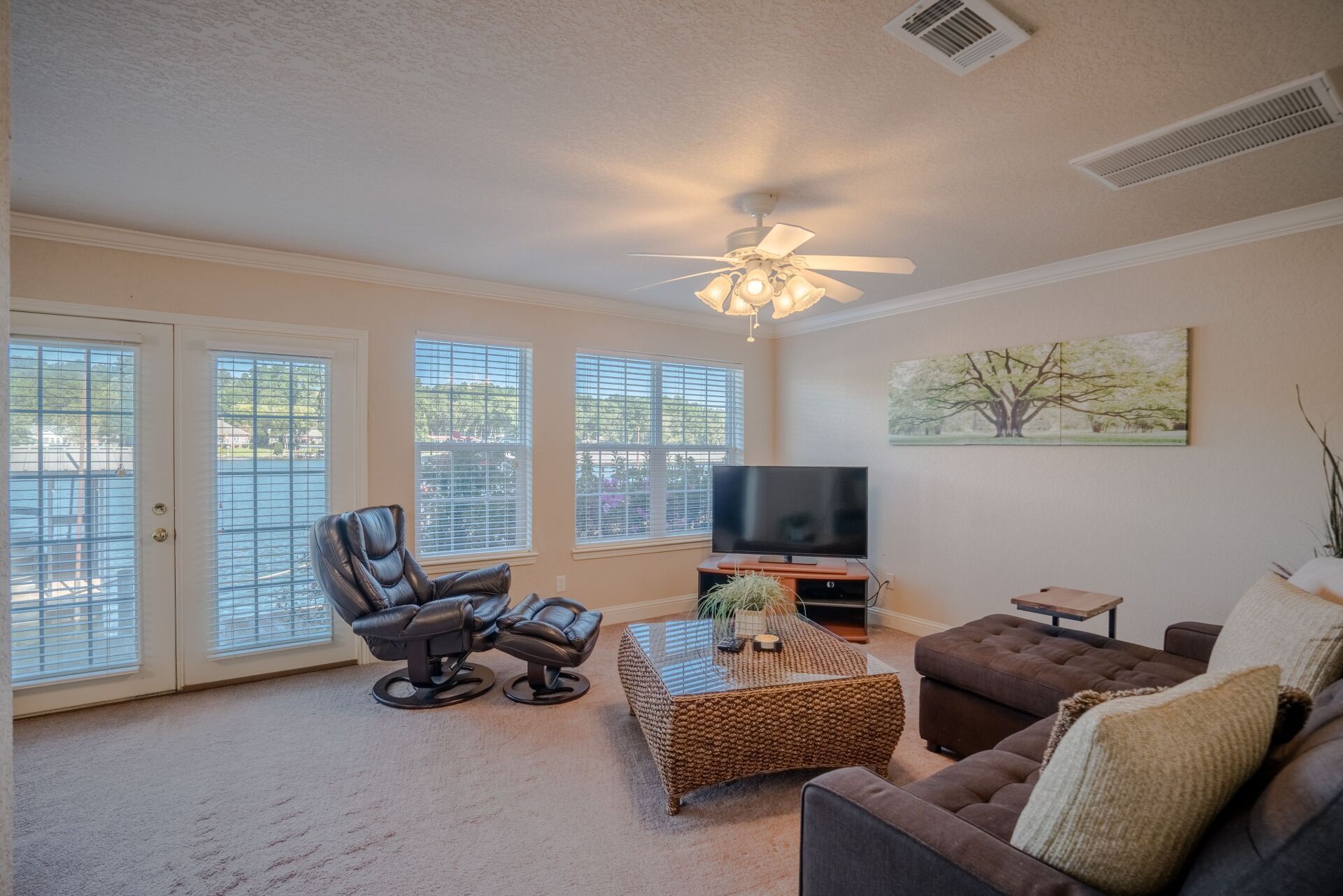 A living room with a couch , chair , coffee table and television.