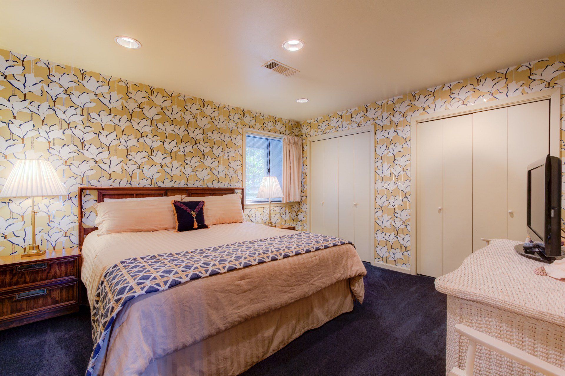 A bedroom with a king size bed and a flat screen tv.