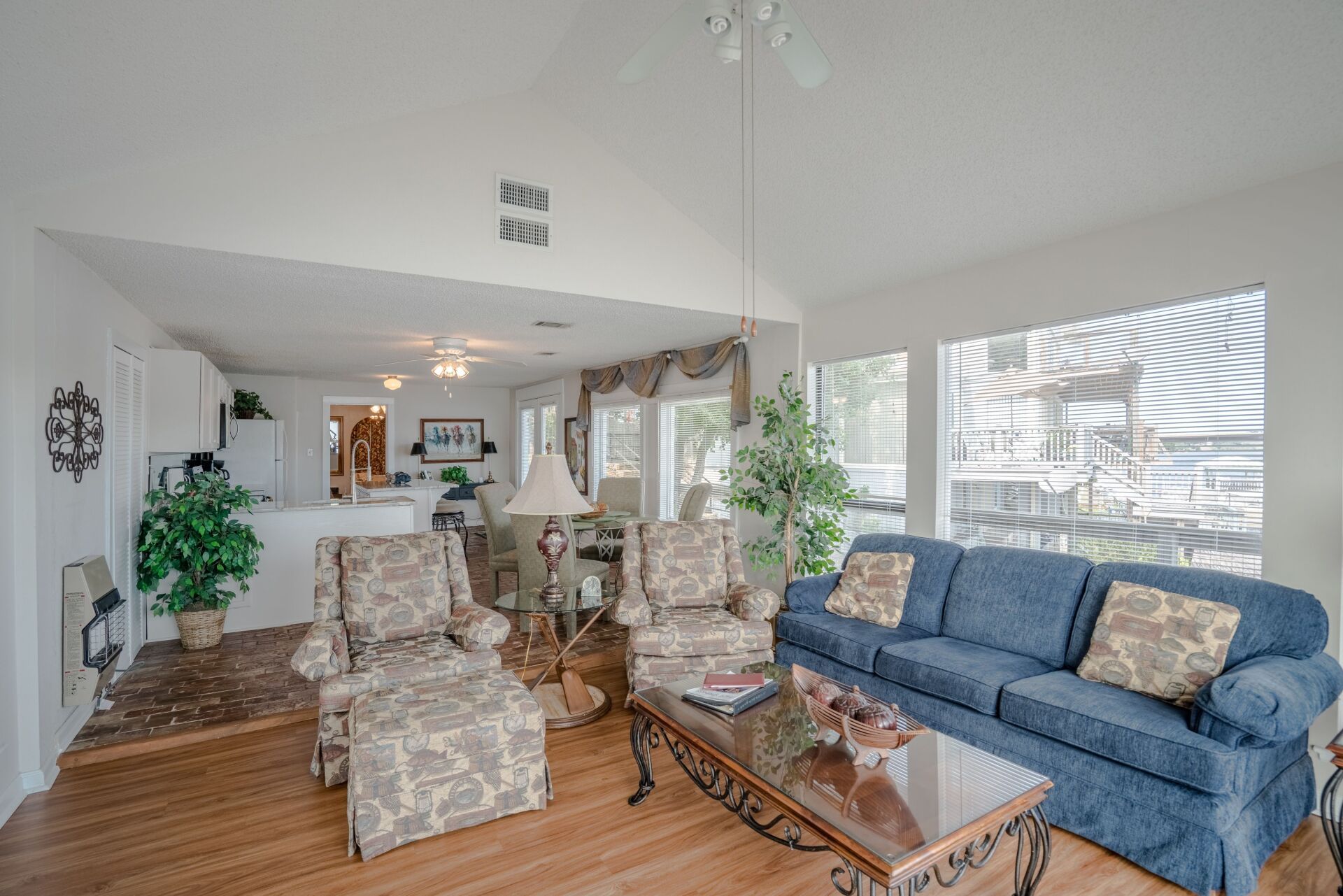 A living room with a blue couch , two chairs , and a coffee table.