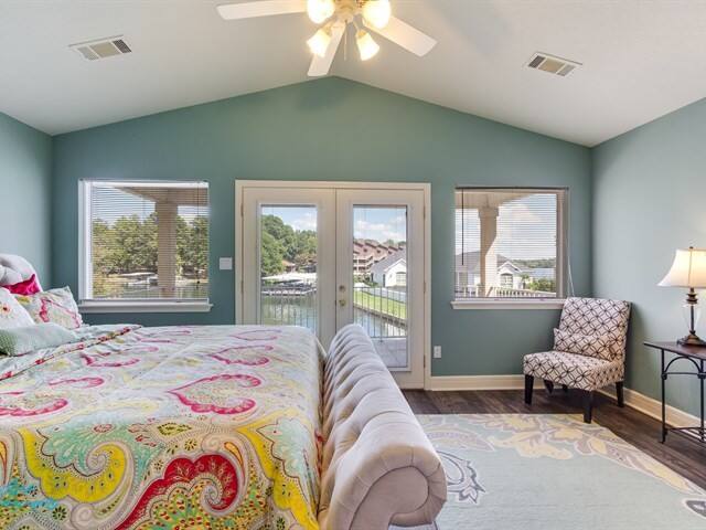 A bedroom with a bed , chair , table and ceiling fan.