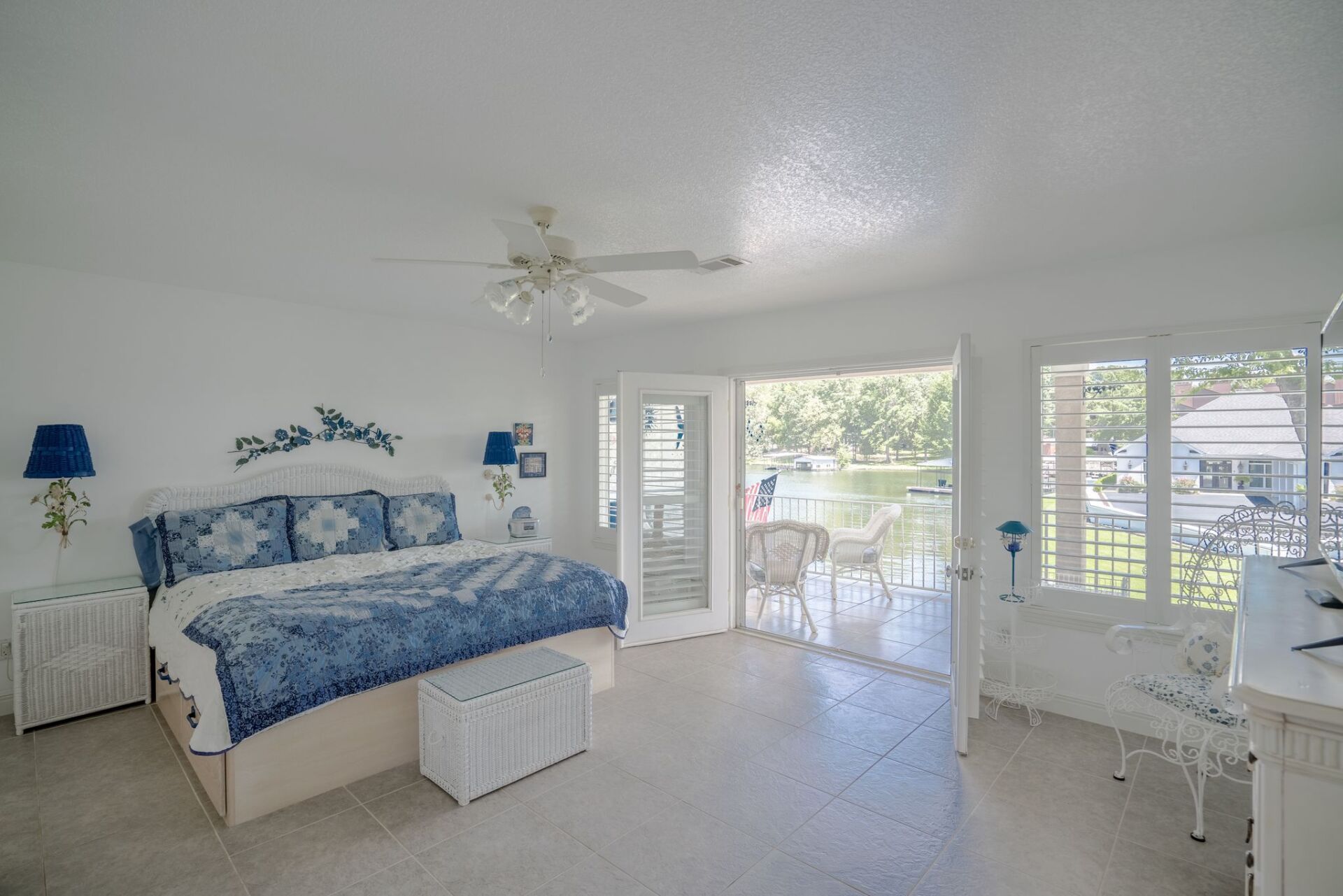 A bedroom with a king size bed and a balcony.