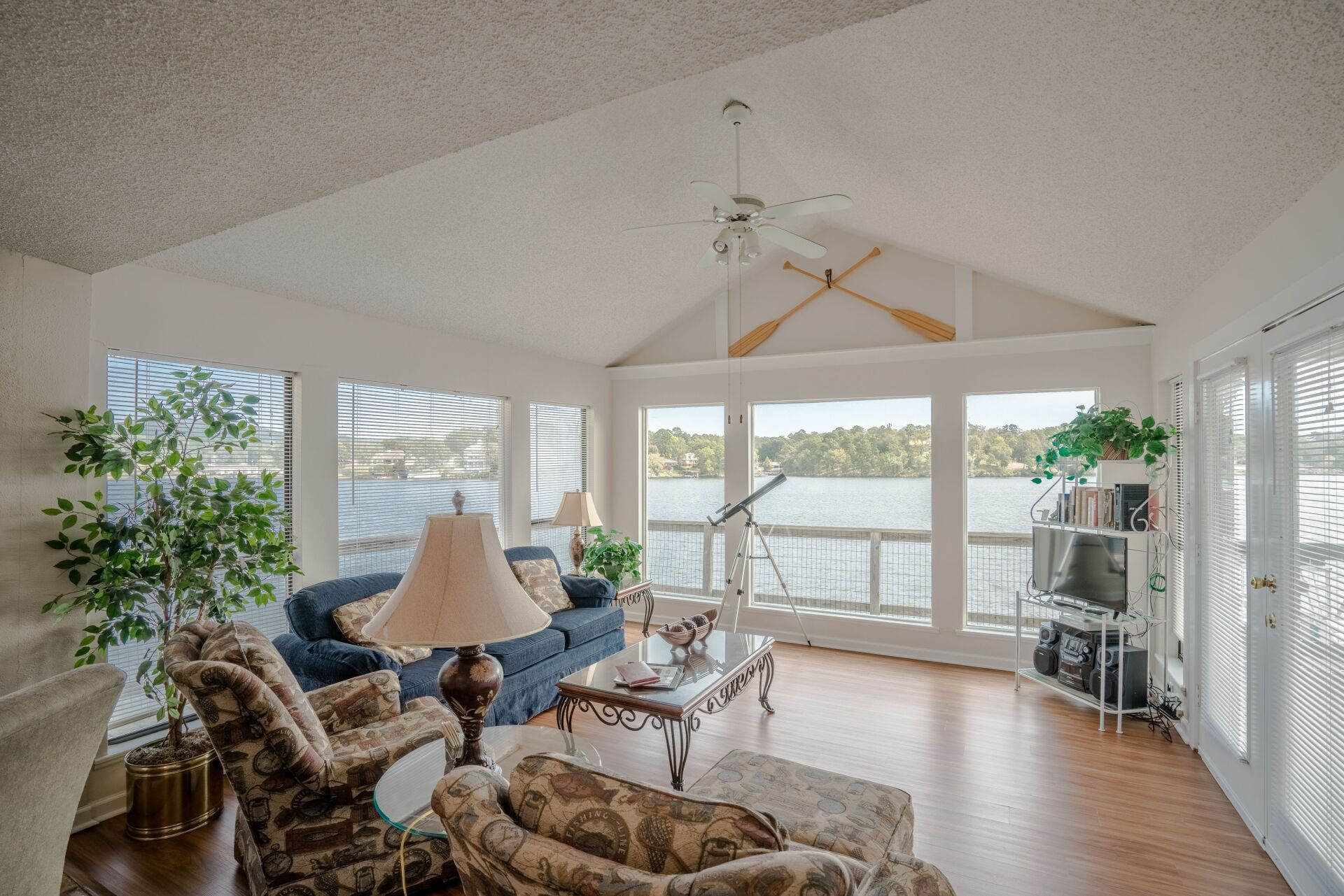 A living room with a lot of windows and a view of a lake