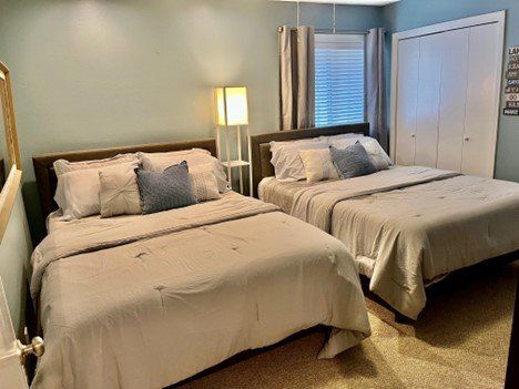A bedroom with two beds and a closet.
