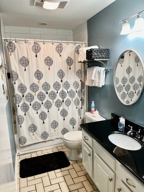 A bathroom with a toilet a sink and a shower curtain