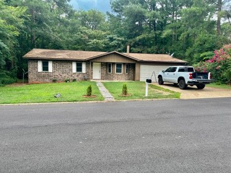 A white truck is parked in front of a house.