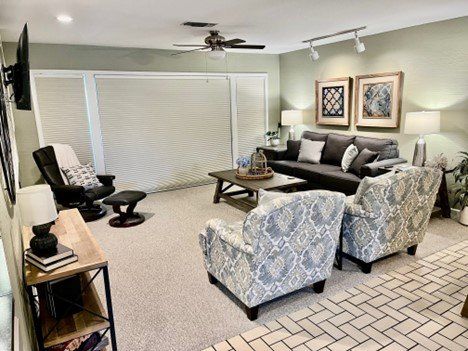 A living room filled with furniture and a ceiling fan.