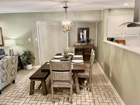 A dining room with a table and chairs and a bench.