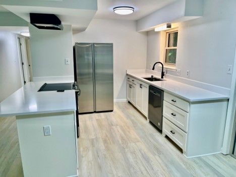 A kitchen with stainless steel appliances and white cabinets.
