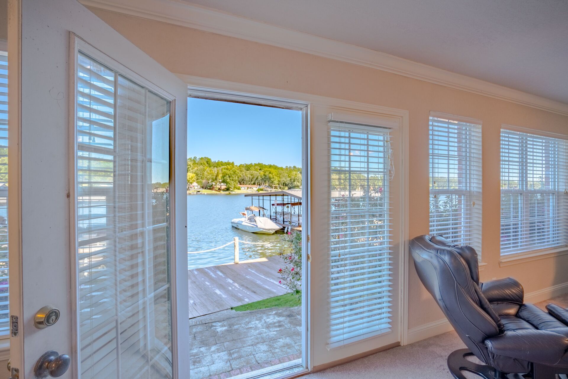 A living room with a view of a lake through a sliding glass door.