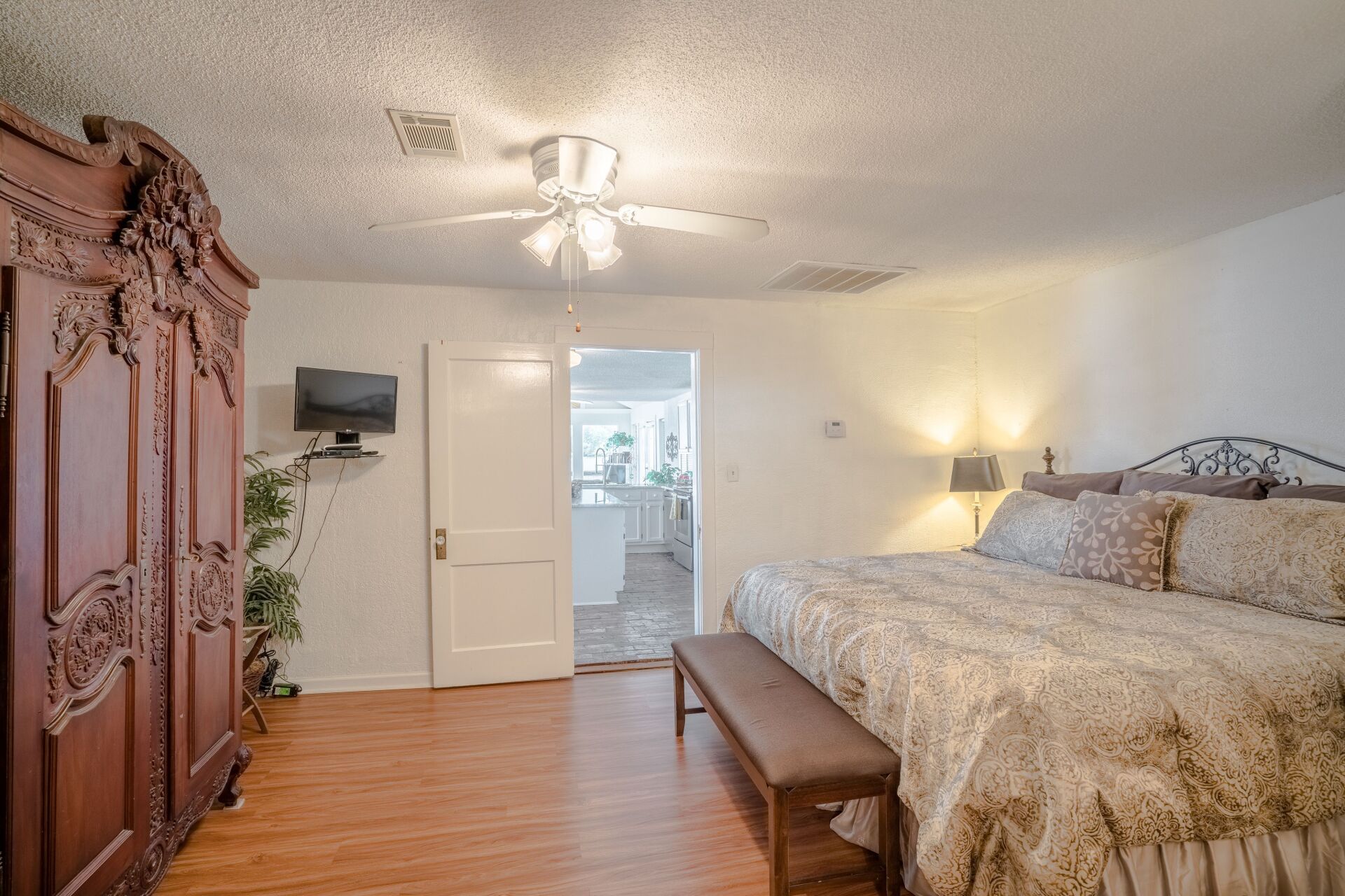 A bedroom with a king size bed and a ceiling fan.