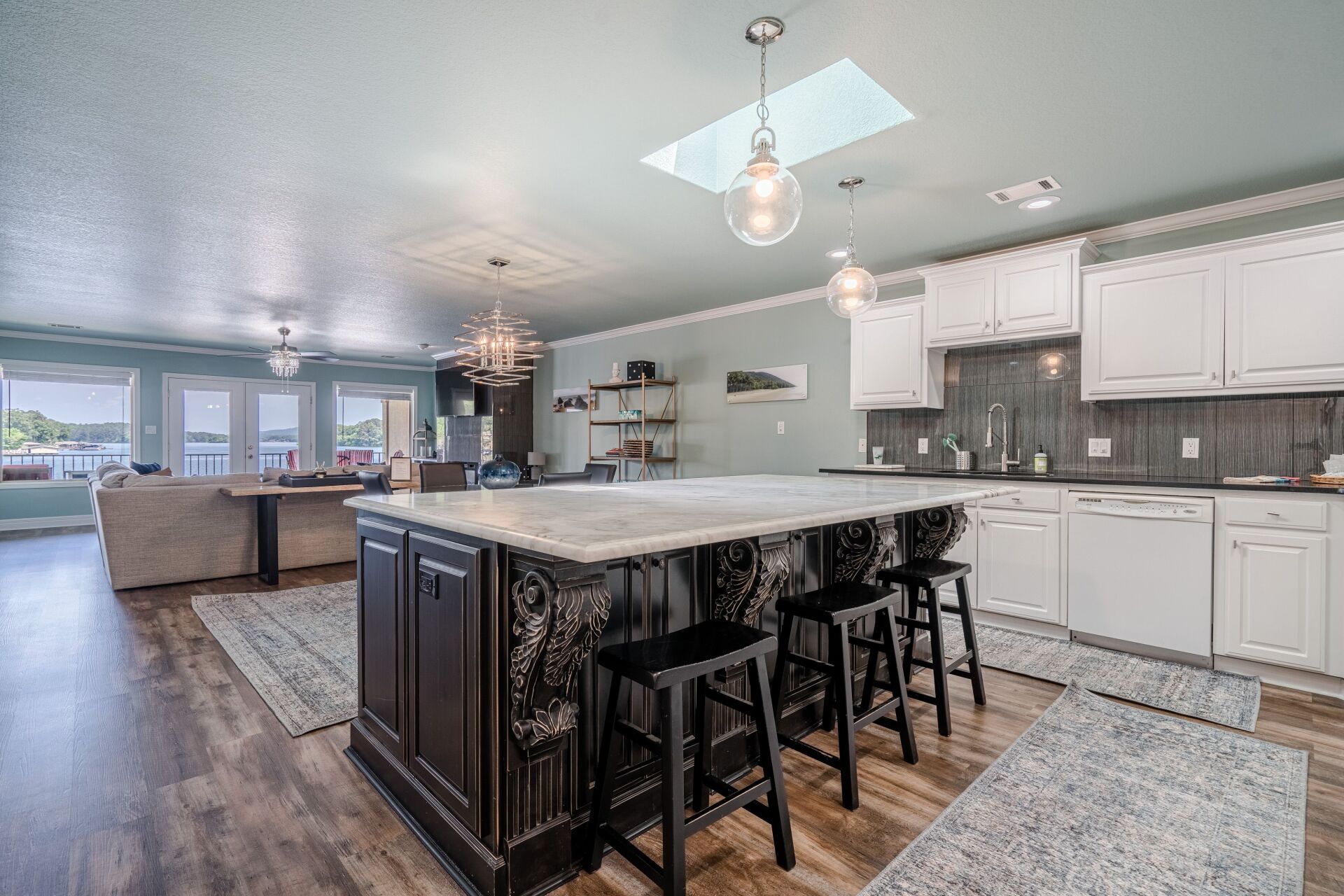 A kitchen with a large island and stools in it.