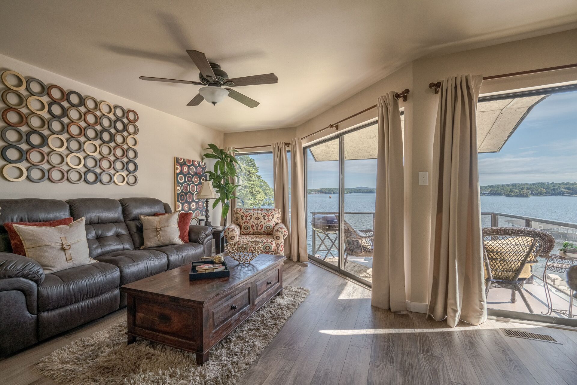 A living room with a couch , table , chairs and a view of the water.