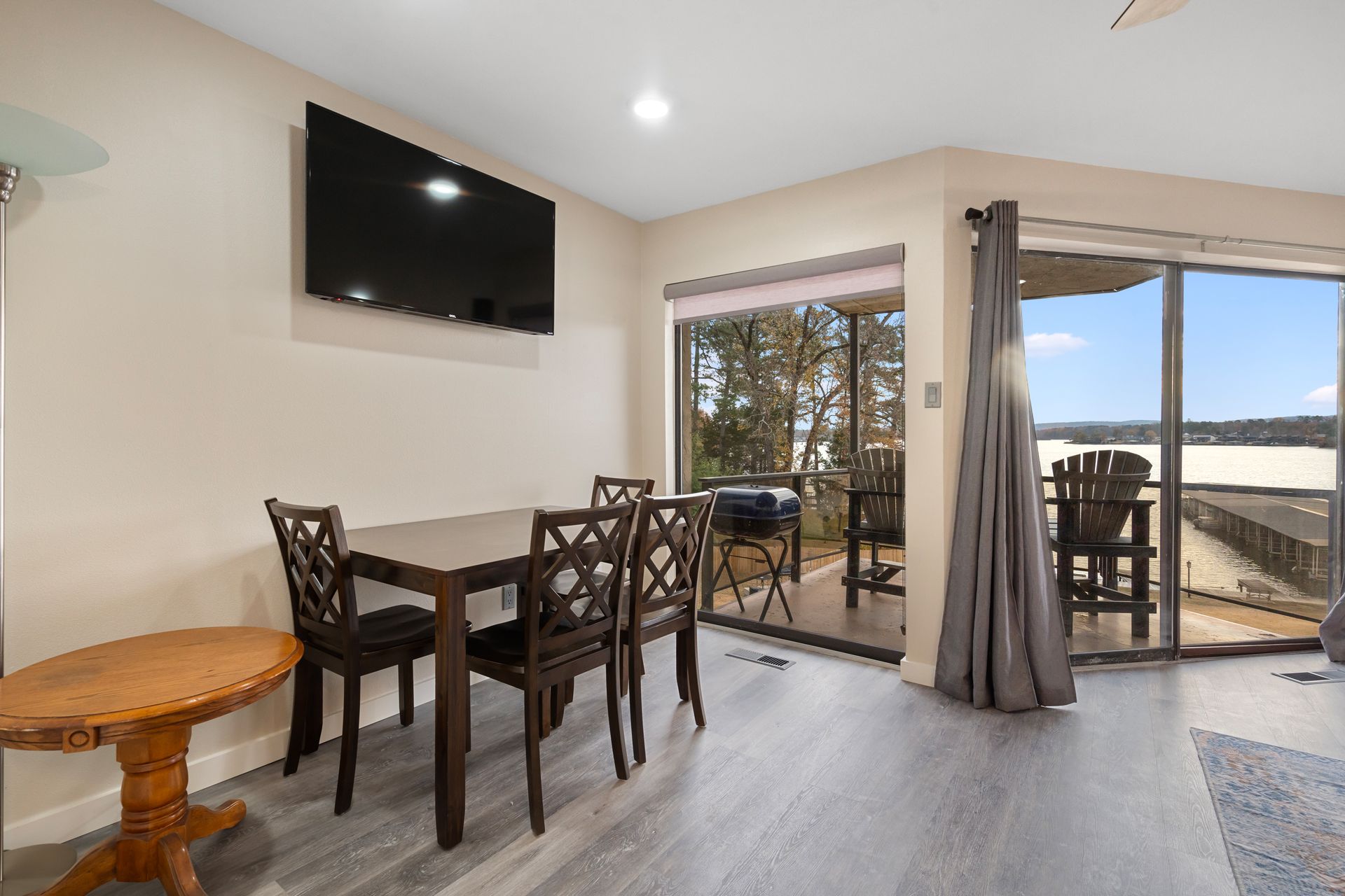 A living room with a table and chairs and a flat screen tv.