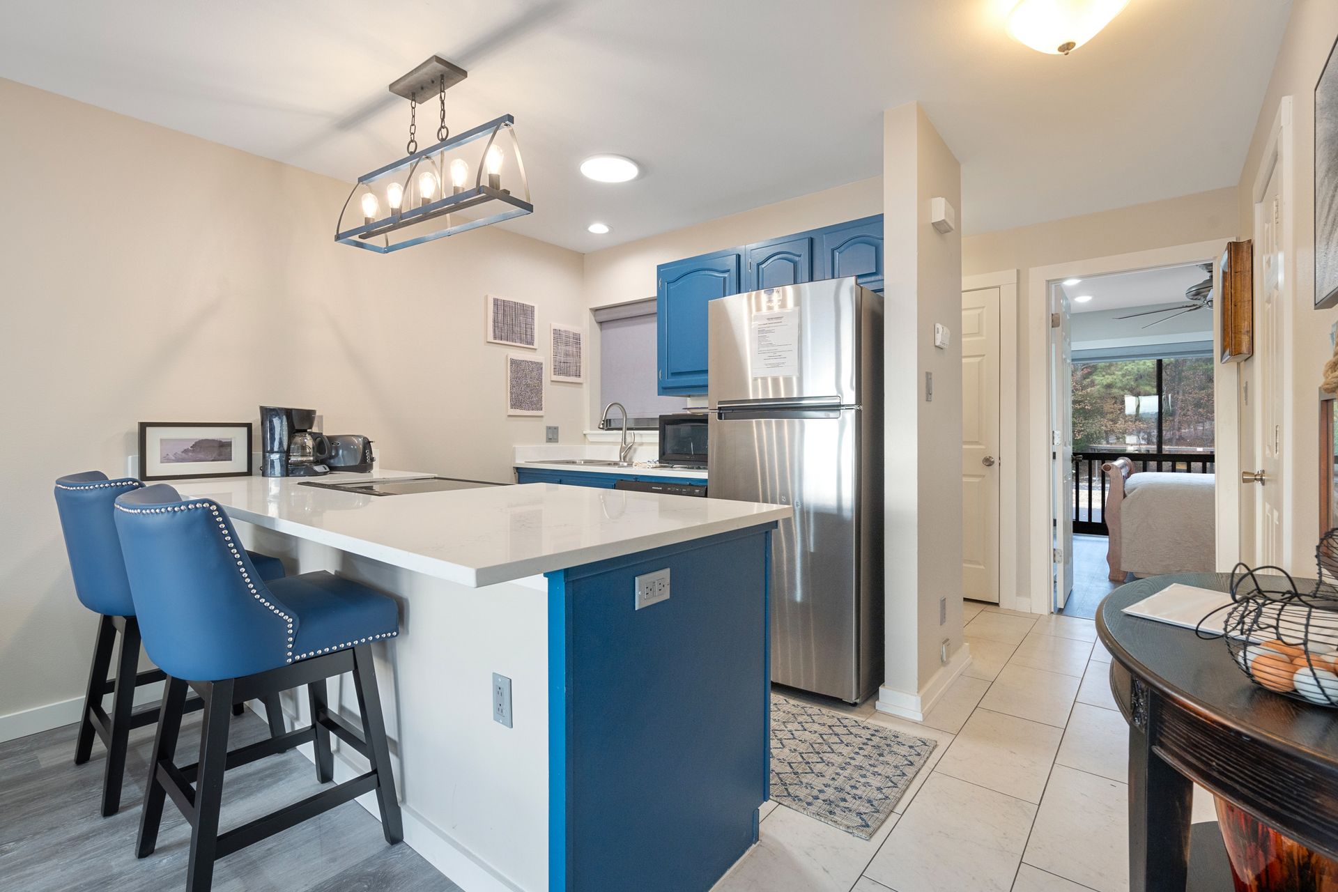 A kitchen with blue cabinets and a stainless steel refrigerator.