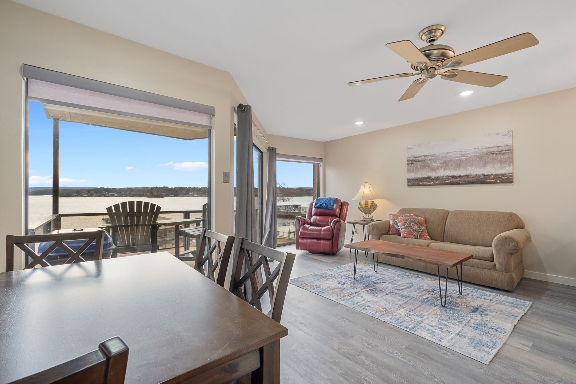 A living room with a couch , table , chairs and a ceiling fan.
