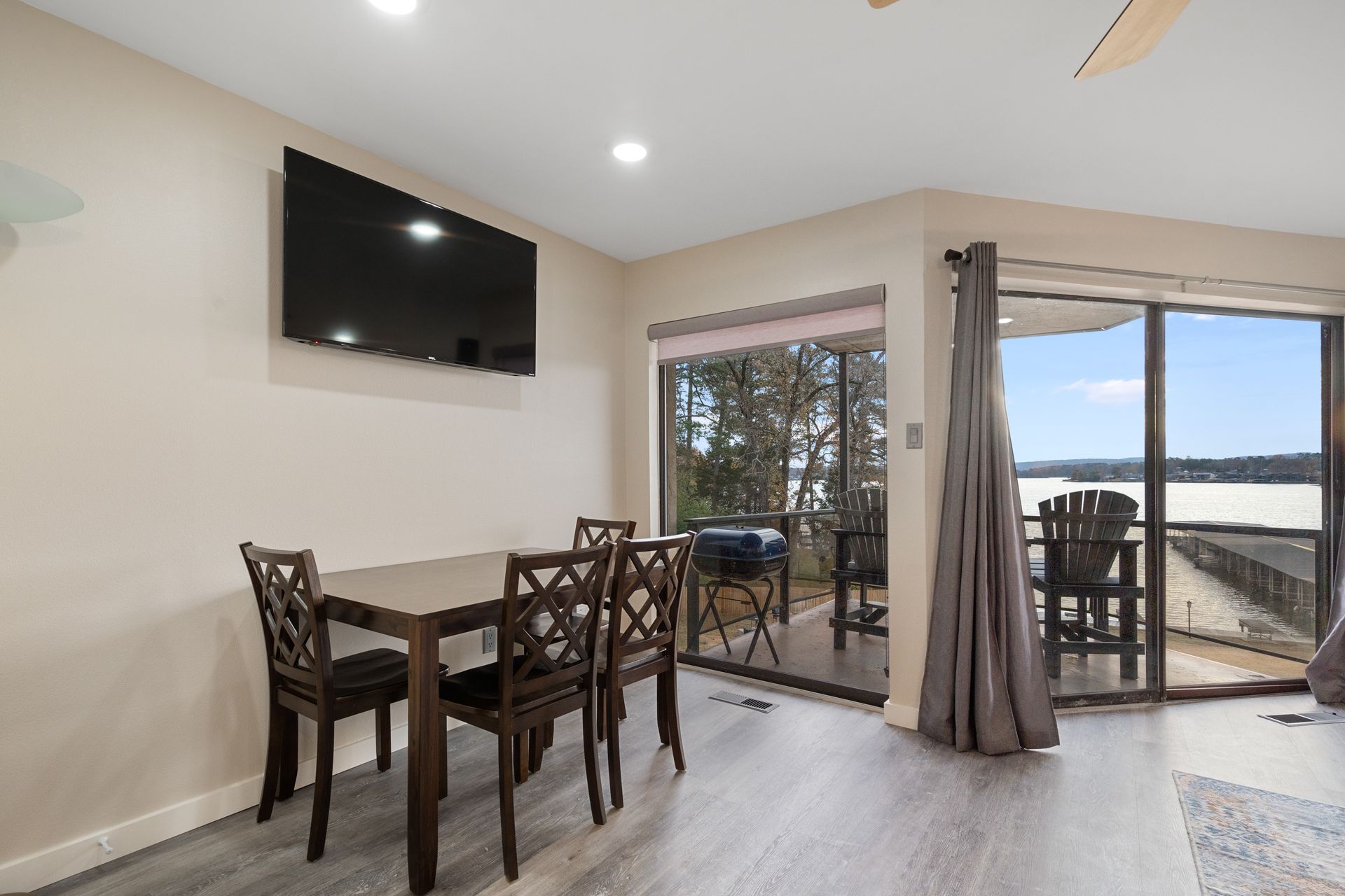 A living room with a table and chairs and a flat screen tv