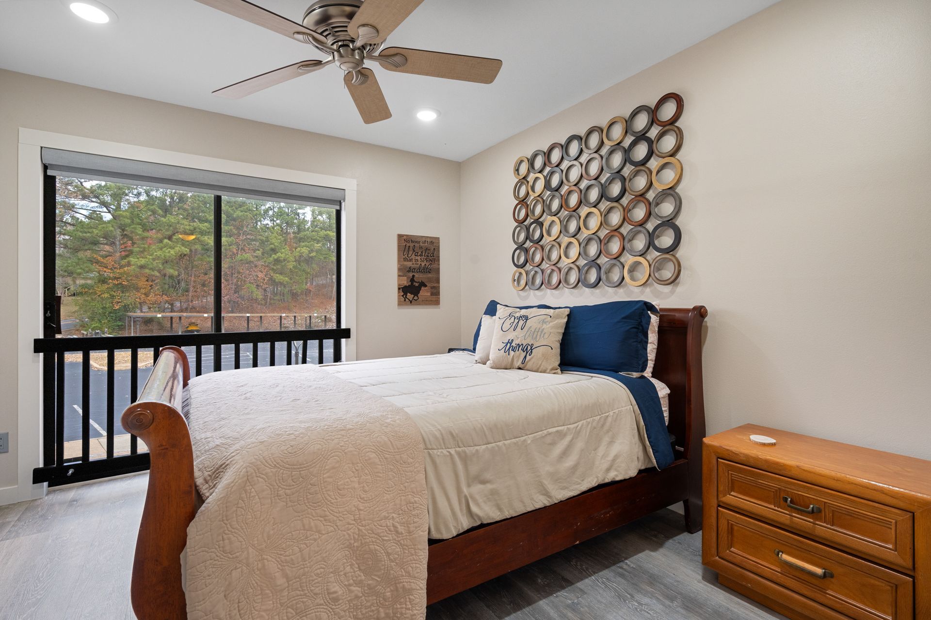A bedroom with a king size bed and a ceiling fan.