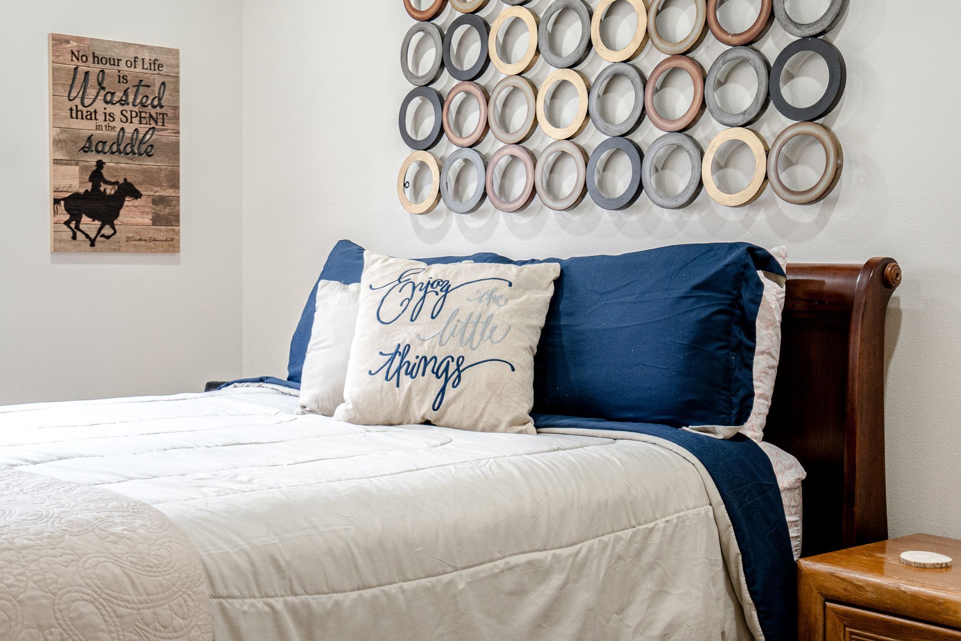 A bedroom with a bed , nightstand , and a sign on the wall.