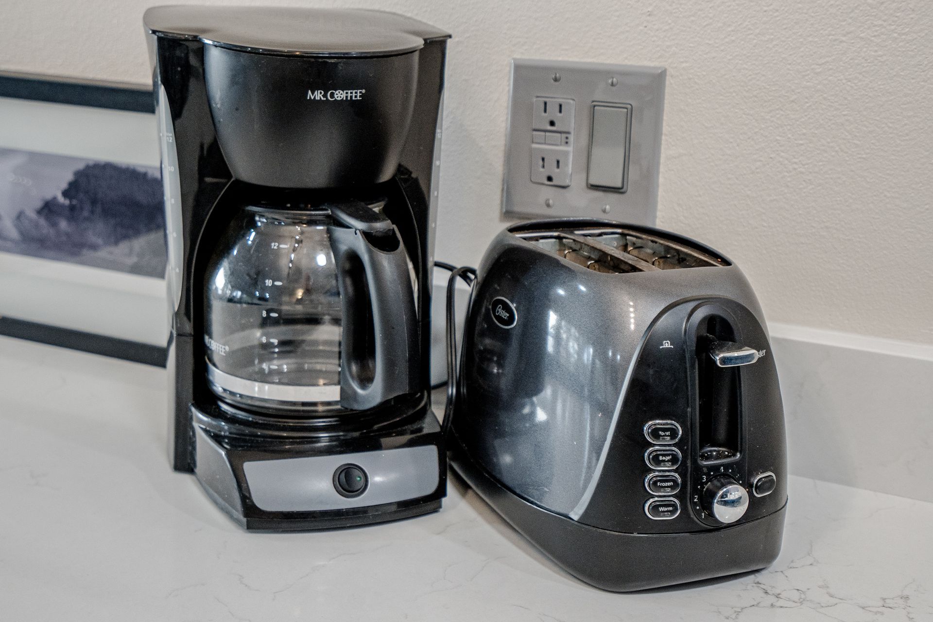 A coffee maker and a toaster are on a counter.