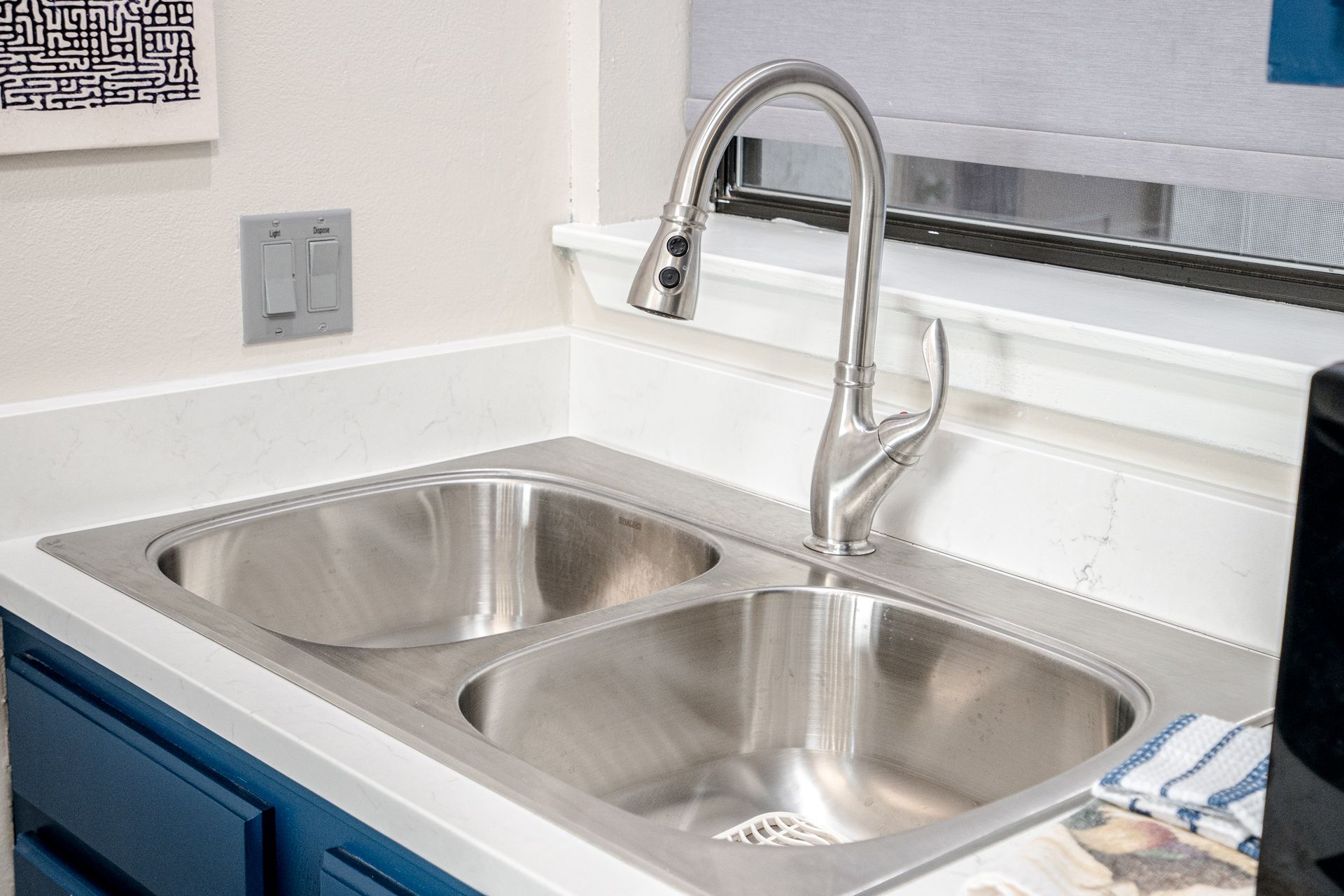 A kitchen sink with two stainless steel sinks and a faucet.