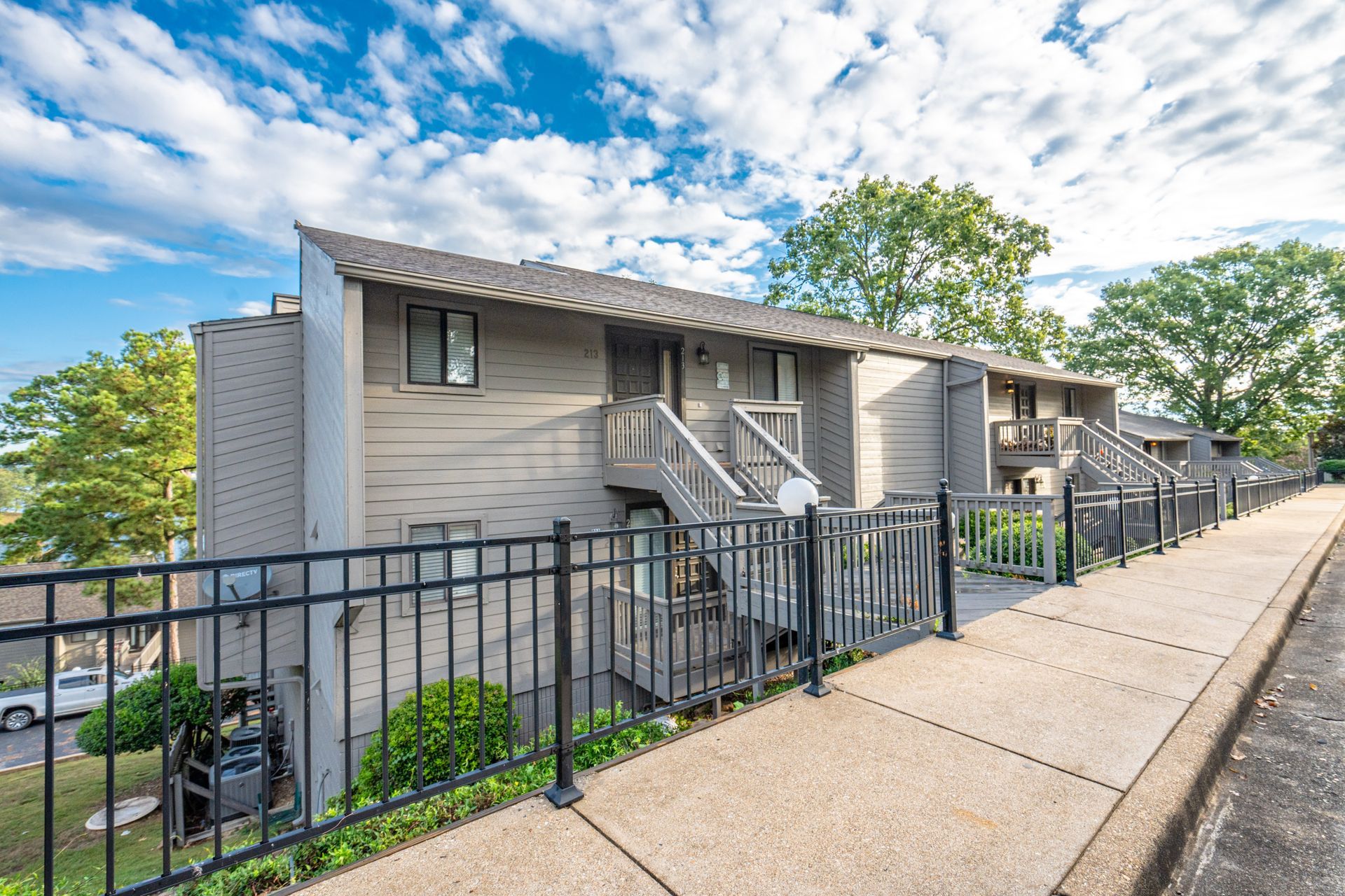 A building with a fence around it and a sidewalk in front of it.