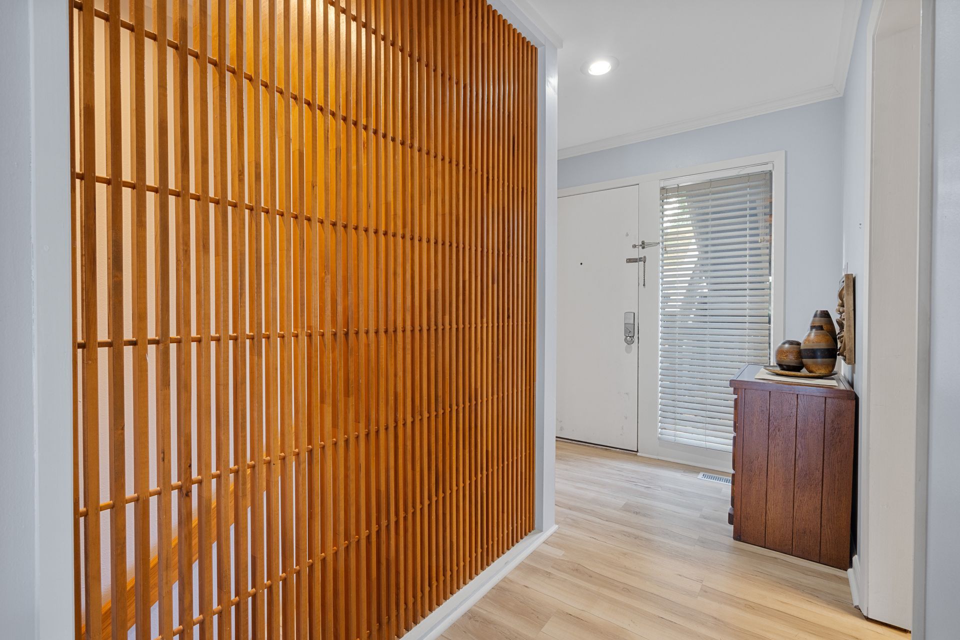 A hallway with a wooden wall and a wooden dresser.