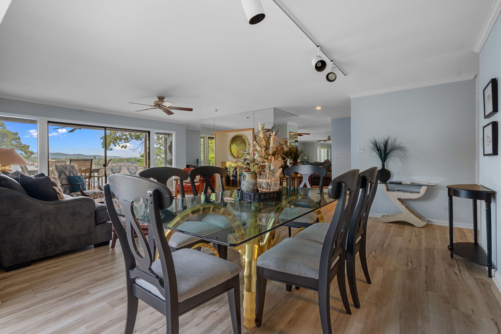 A dining room with a glass table and chairs in a house.