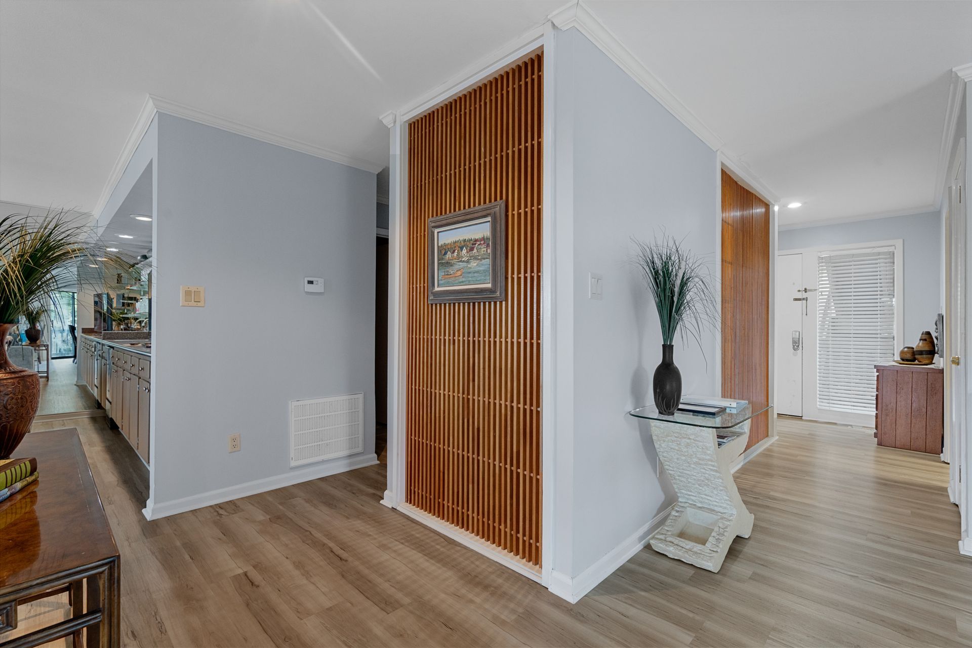 A hallway in a house with hardwood floors and a wooden wall.