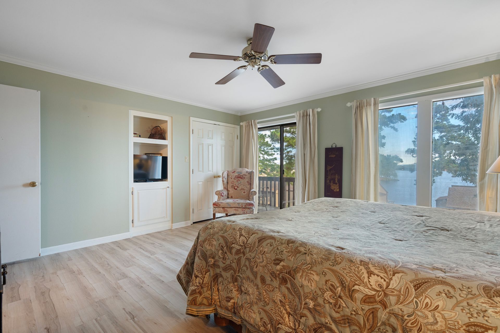 A bedroom with two beds , a chair and a ceiling fan.