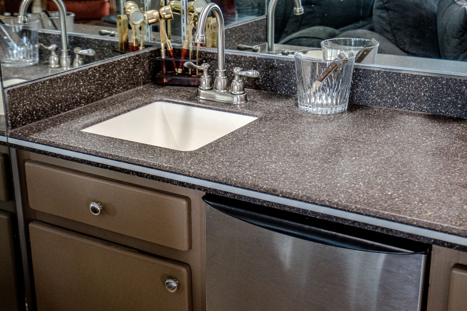 A kitchen counter with a sink and a stainless steel dishwasher.