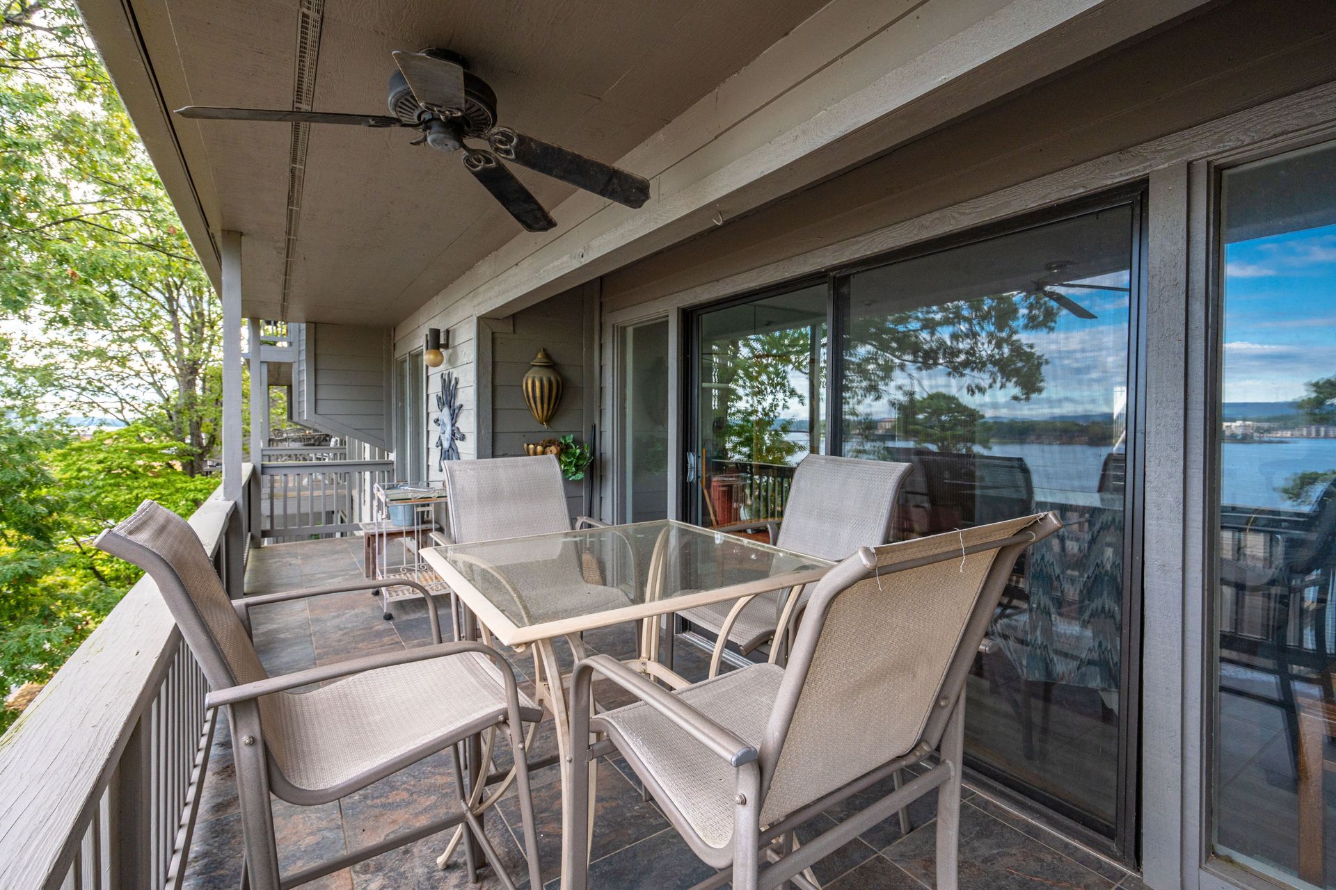A balcony with a table and chairs and a ceiling fan.