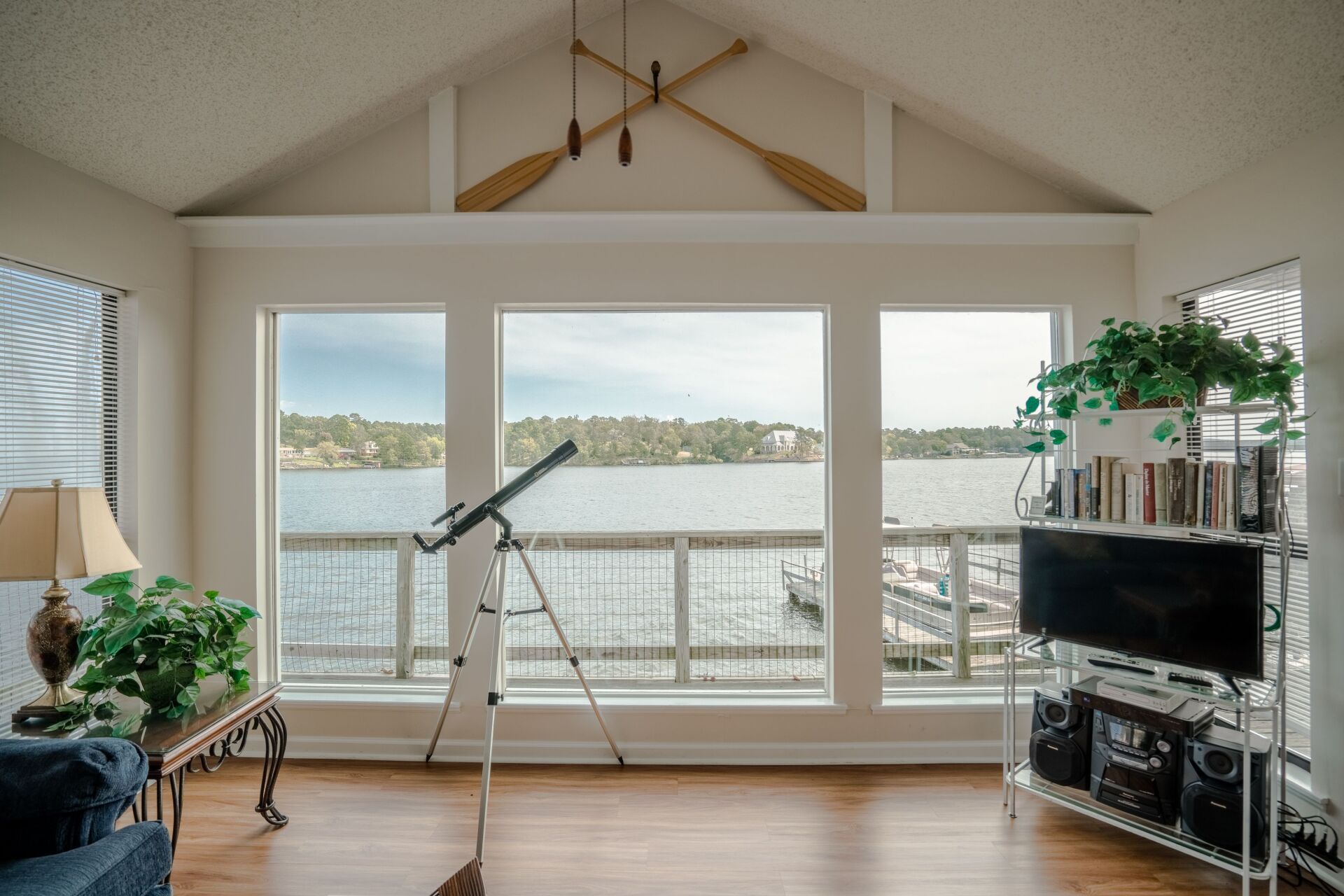 A living room with a view of a lake and a telescope.