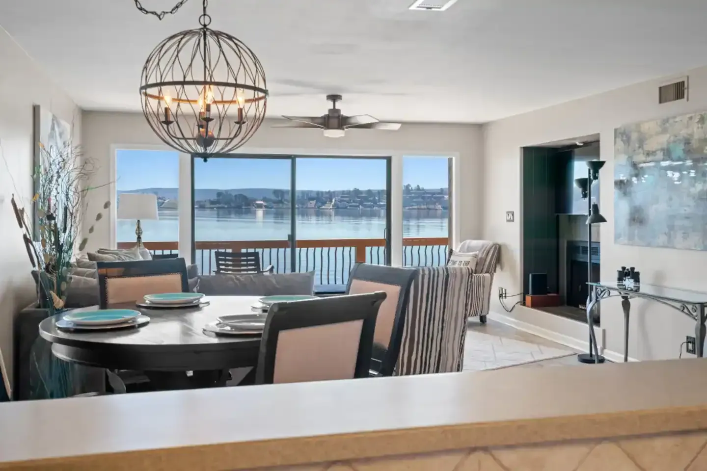 A living room with a table and chairs and a view of the water