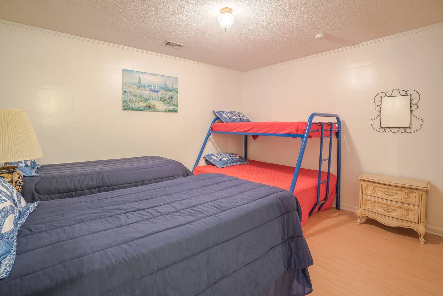 A bedroom with two beds and a bunk bed.