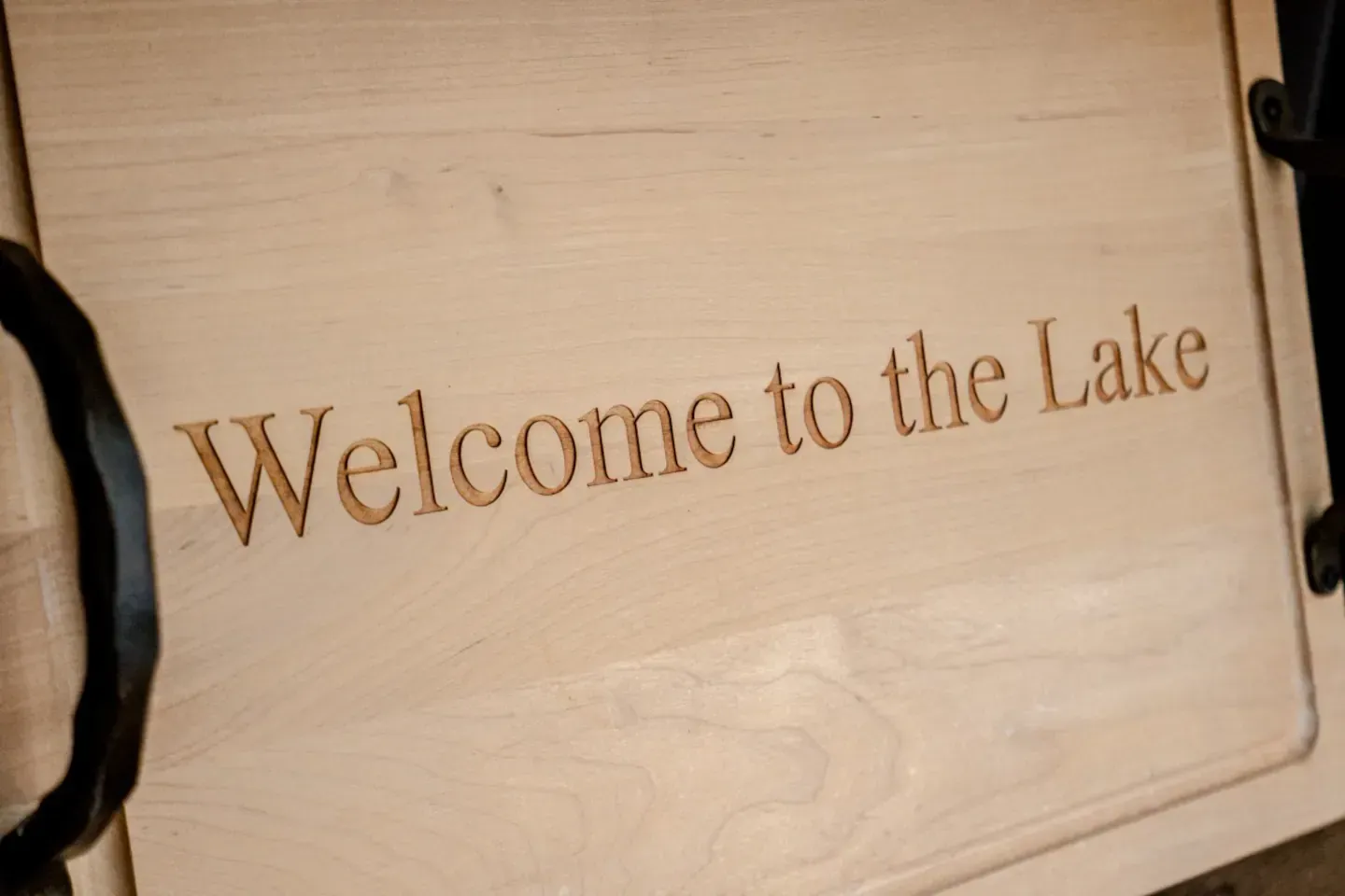 A wooden sign that says welcome to the lake on it