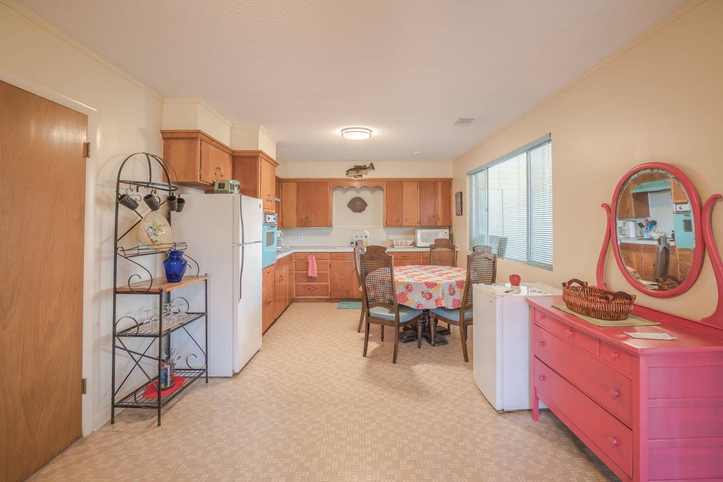 There is a pink dresser in the middle of the room.