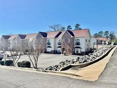 A large apartment building with a parking lot in front of it.