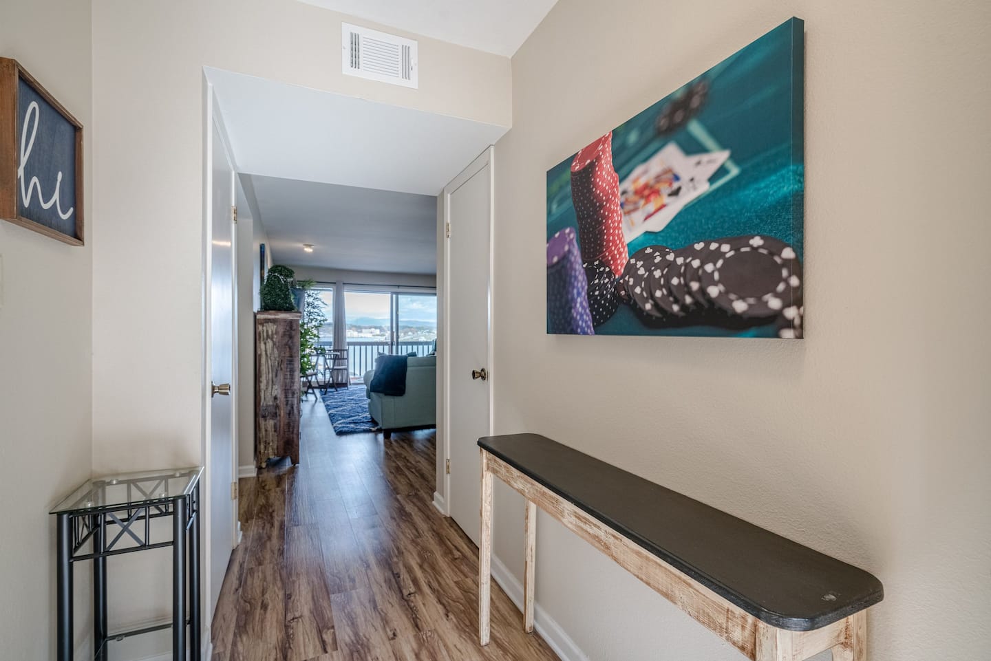 A hallway with a table and a painting on the wall.