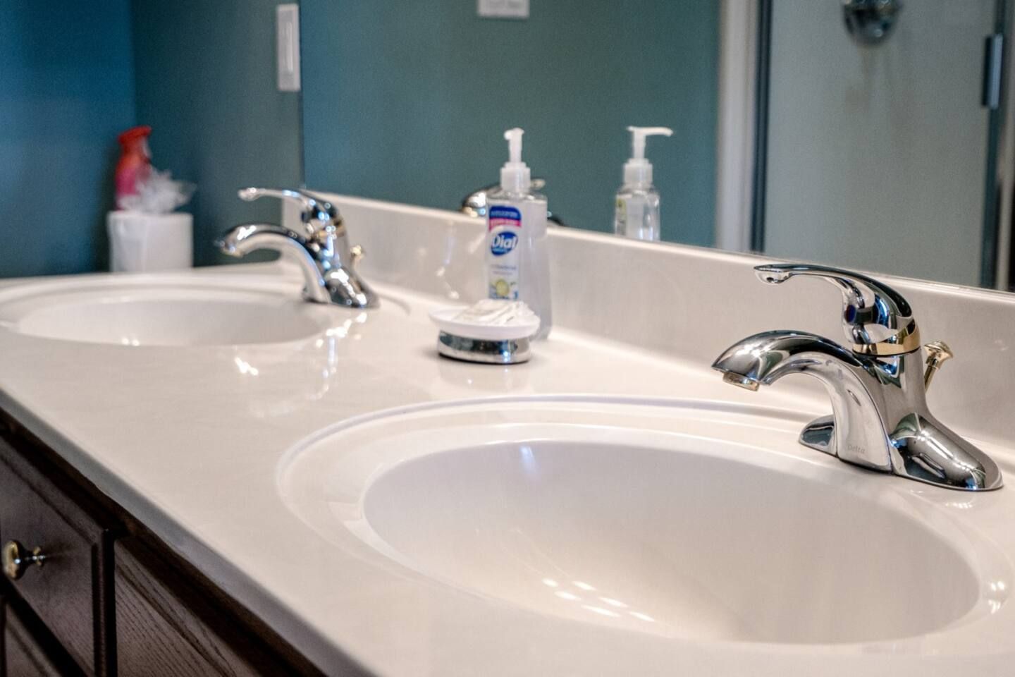 A bathroom with two sinks and a mirror.