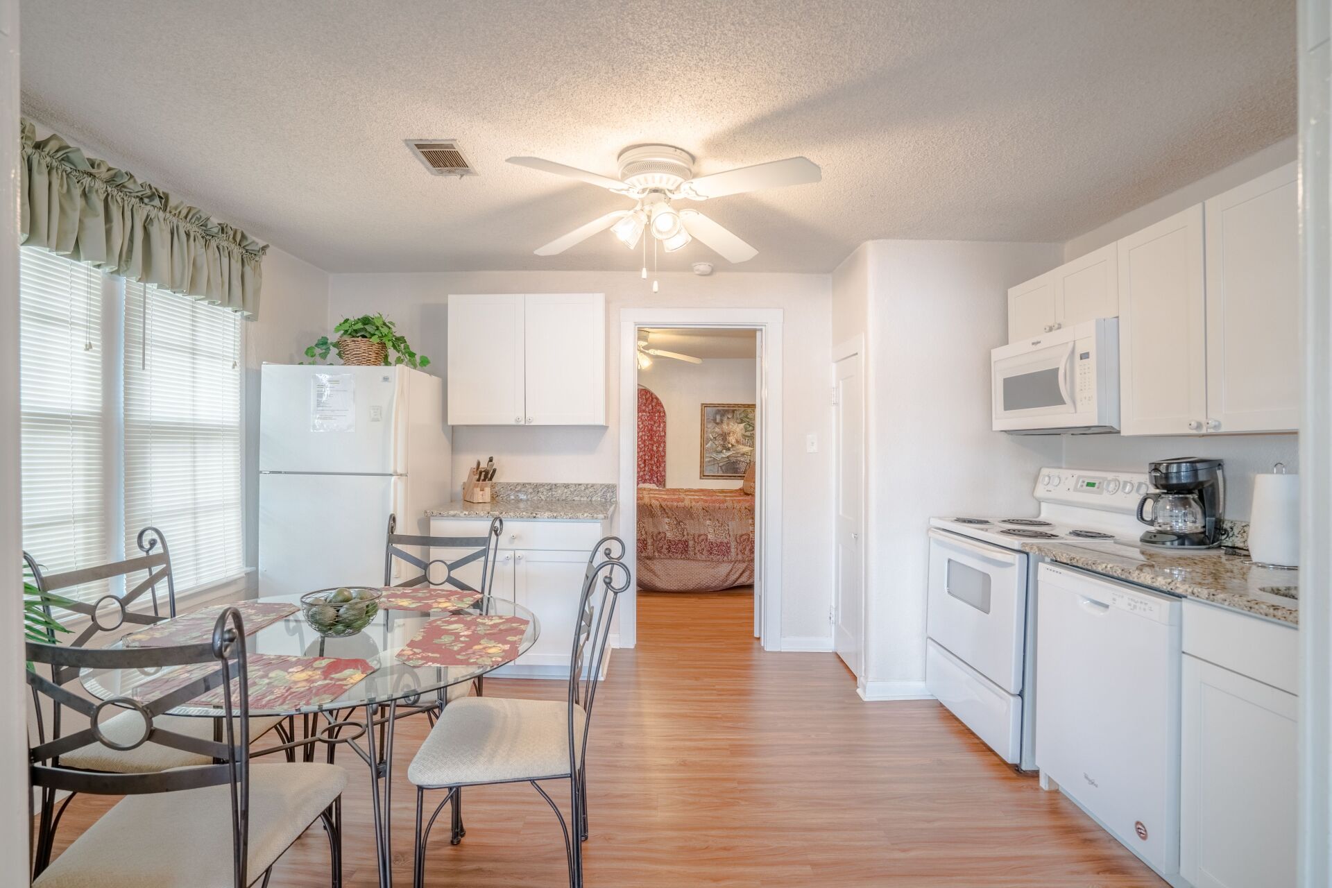 A kitchen with a table and chairs and a ceiling fan