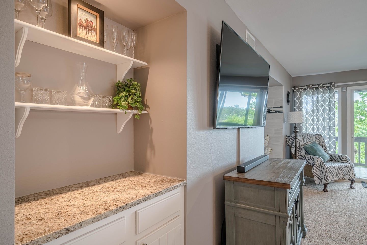A living room with a large flat screen tv on the wall.