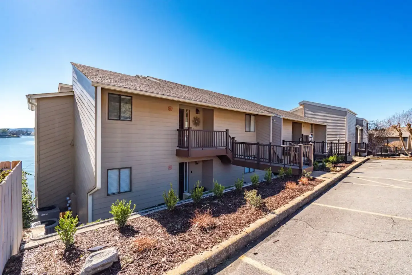 A large apartment building with a balcony overlooking a body of water.