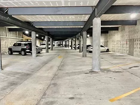 A parking garage with a lot of cars parked in it.