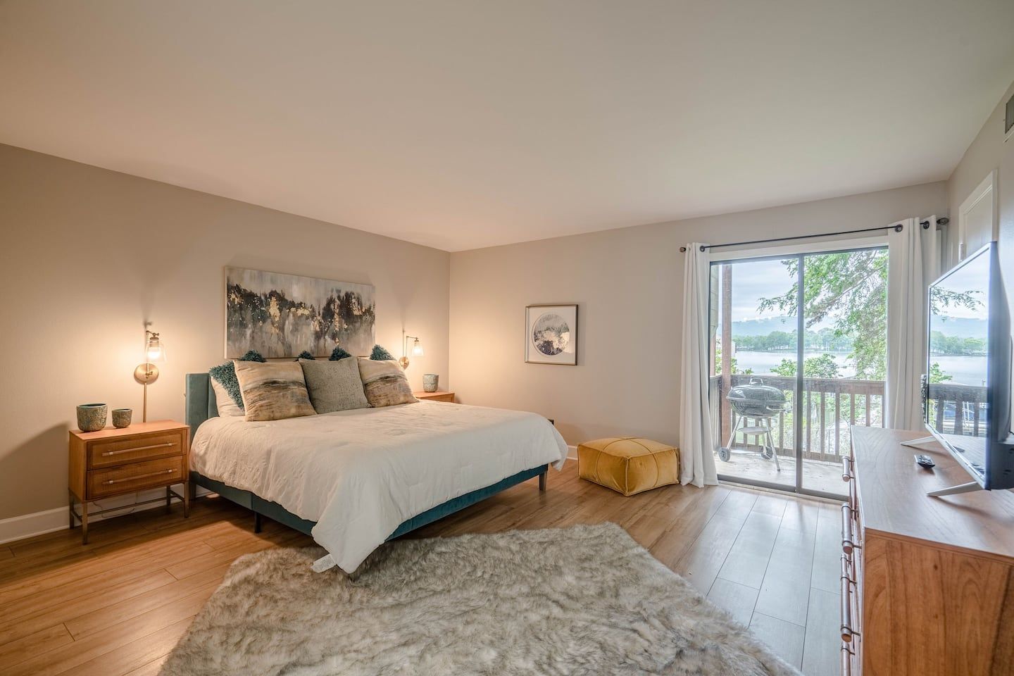 A large bedroom with a king size bed , dresser , and television.