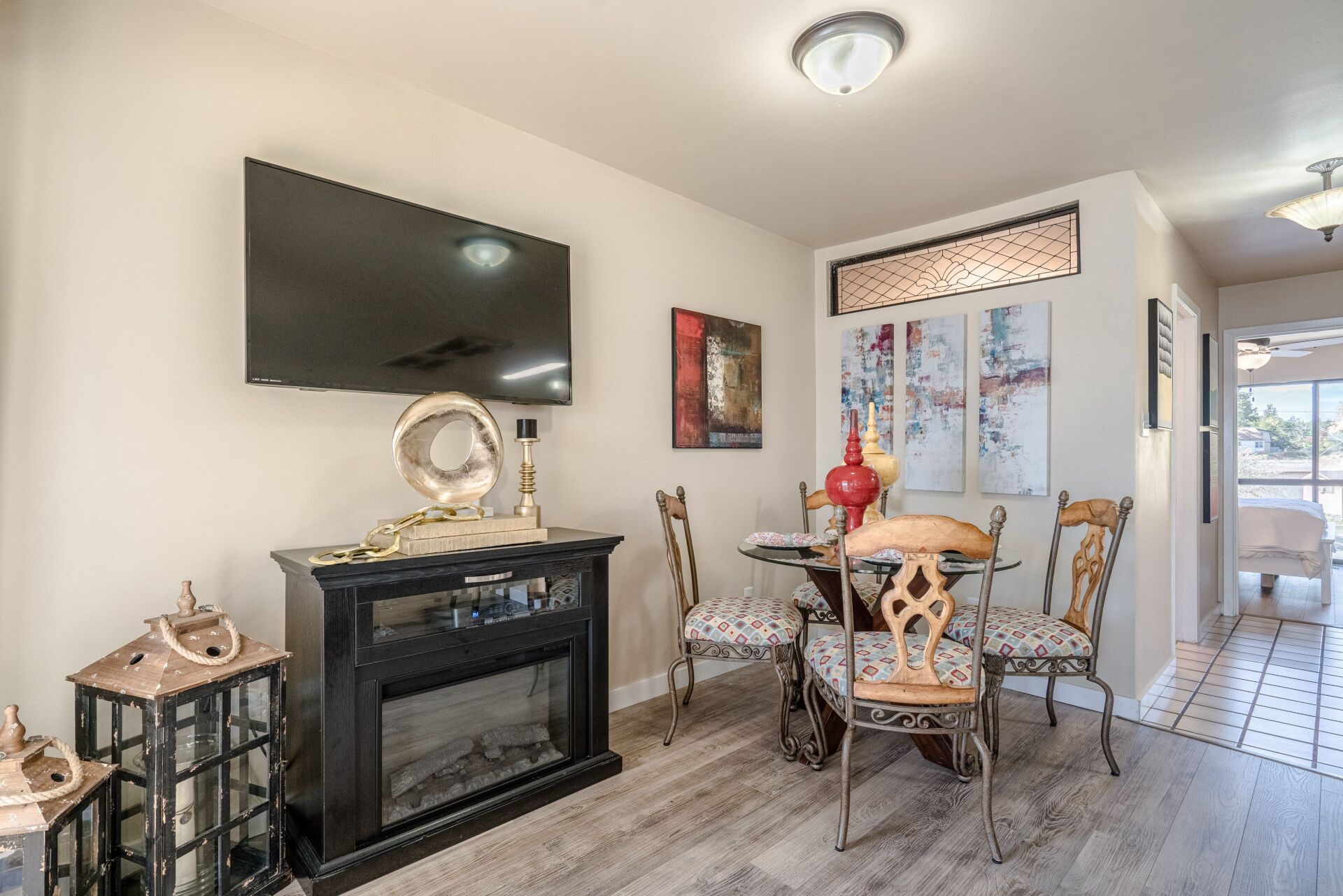 A living room with a fireplace , television , table and chairs.