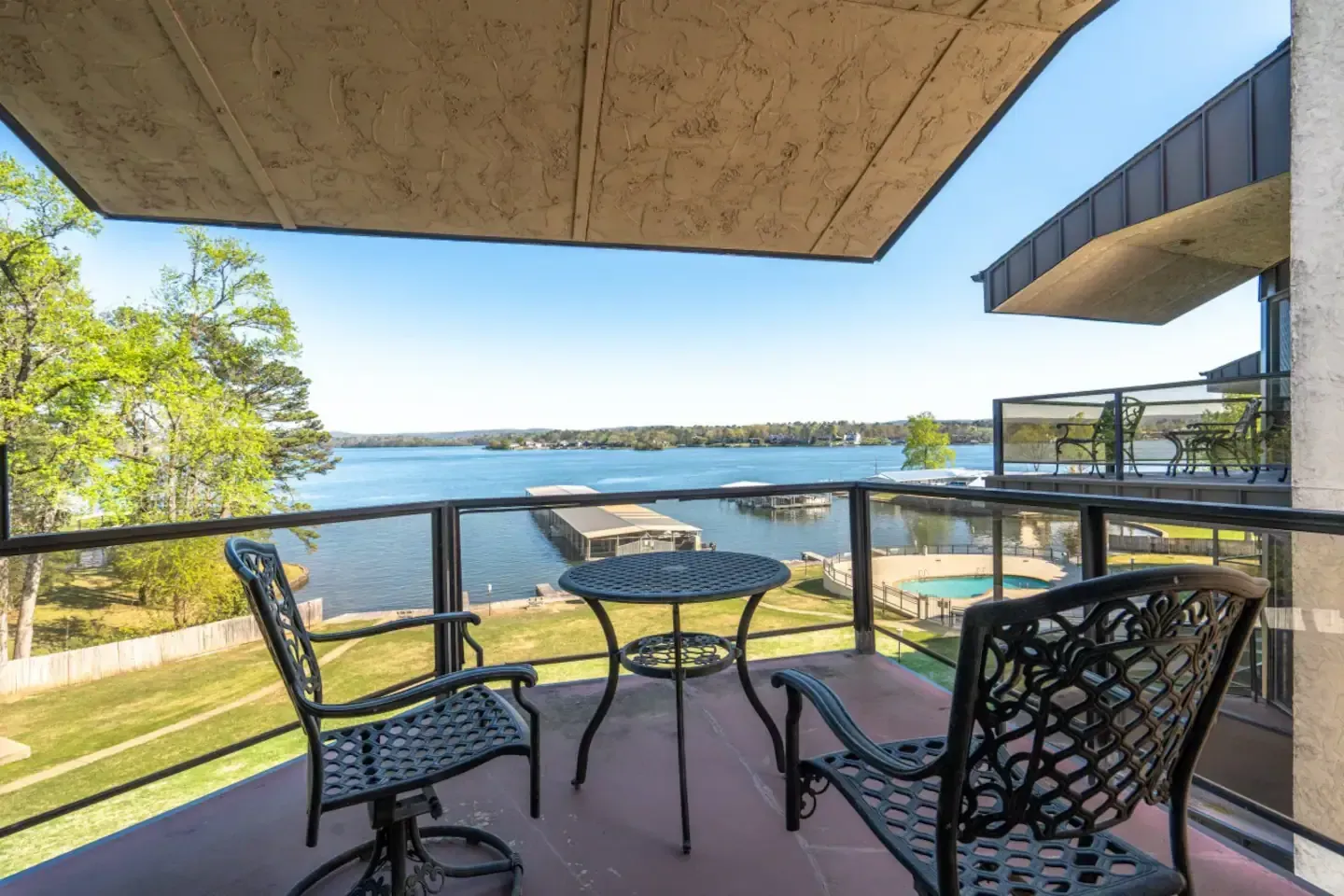 A balcony with a table and chairs overlooking a lake.