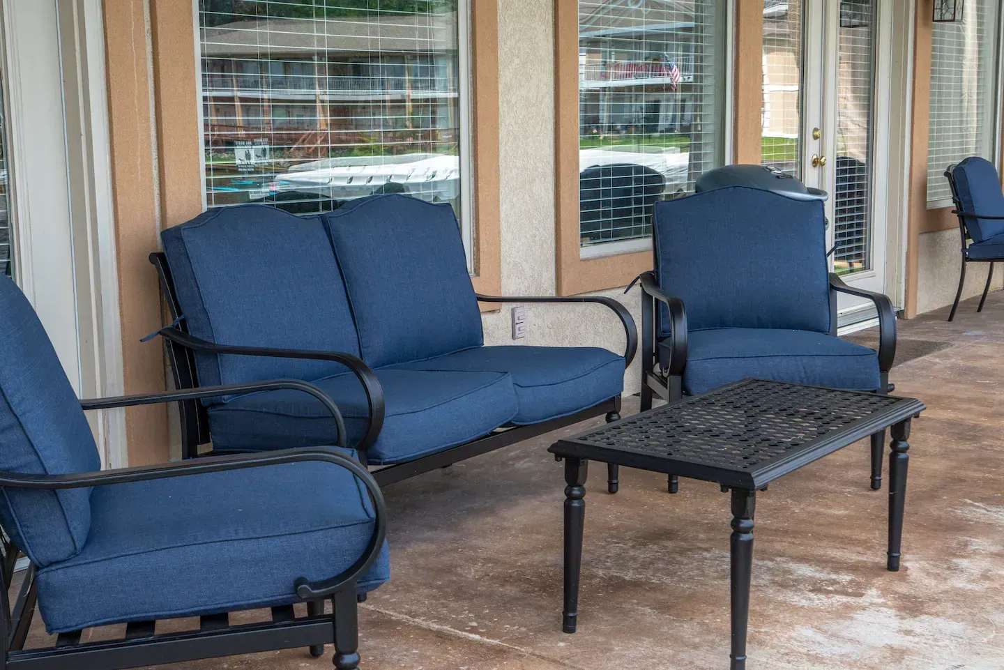 A patio with a couch , chairs , and a table.