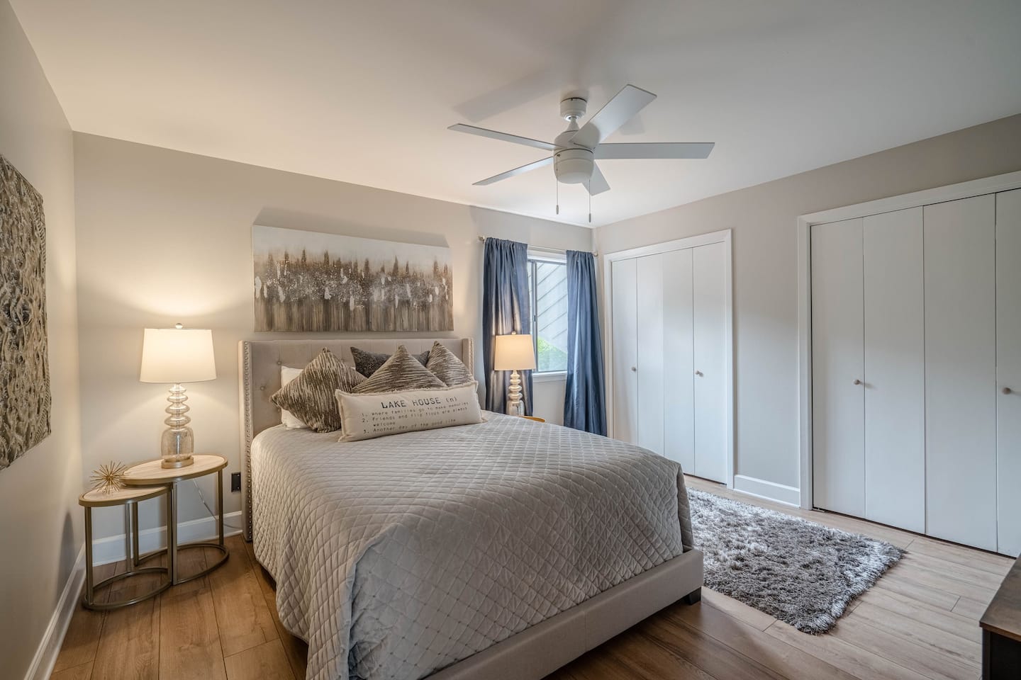 A bedroom with a king size bed , a ceiling fan , and a rug.