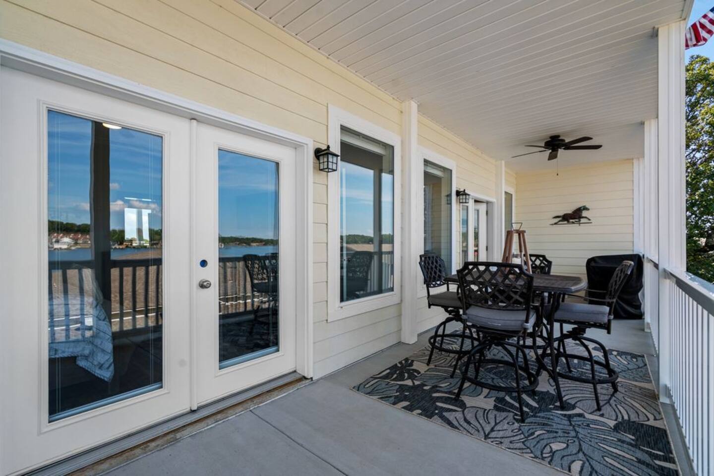 A large porch with a table and chairs and a ceiling fan.