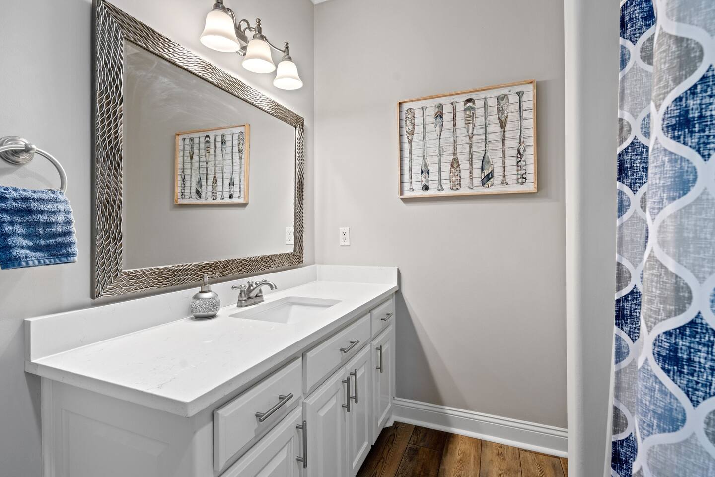 A bathroom with a sink , mirror , and shower curtain.